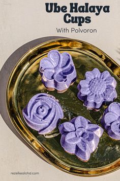 purple cupcakes are on a gold plate with leaves and flowers in the middle