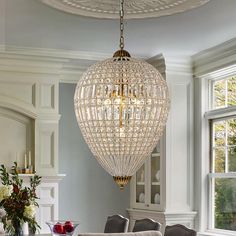 a chandelier hanging from the ceiling in a dining room with chairs and table