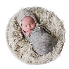 a newborn baby wrapped in a blanket and wearing a hat