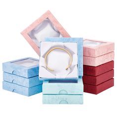 three different colored boxes with a gold bracelet in it's middle and one empty box on the other side