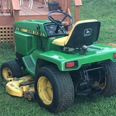 a green lawn mower sitting in the grass