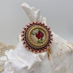 "This beautiful hand beaded brooch is hand embroidered with a glass cabochon in the center, with an image of a vintage rose. Embellished with seed beads in beige and red colors. Made with sturdy beading thread, it is backed with corduroy and has a gold-colored Japanese pin back. These make great hat pins or scarf pins too! This unique hand beaded brooch measures 1.85\" (47mm)" Unique Handmade Round Brooches, Handmade Wedding Brooches, Handmade Round Wedding Brooches, Scarf Pins, Beading Thread, Scarf Pin, Rose Vintage, Beaded Brooch, Vintage Rose