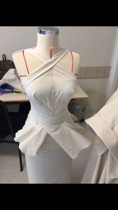 a mannequin is dressed up in white clothing