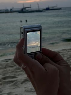 someone is taking a photo on their cell phone at the beach