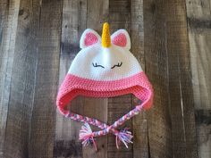 a crocheted hat with a pink and white unicorn face