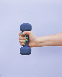 a woman's hand holding a blue object in the air