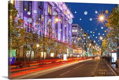 the city street is lit up with christmas lights