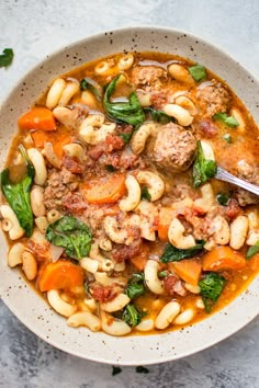 a white bowl filled with pasta and meat soup