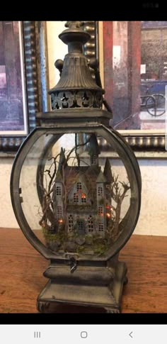 an old fashioned lantern with a house in it