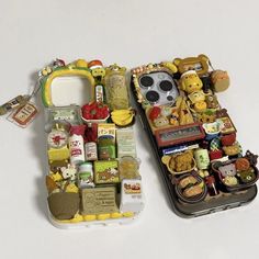 two cell phones are covered in miniature food items and have been placed on top of each other