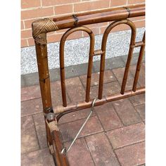 a bamboo bed frame with two metal bars on the top and one is bent down