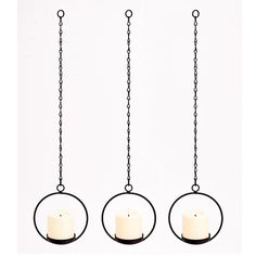 three candle holders hanging from chains in the shape of circles with candles on each one