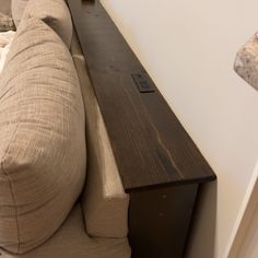 a couch sitting next to a table with a remote control on it's arm