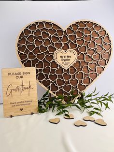 a heart shaped wooden sign next to a card board with hearts cut out of it