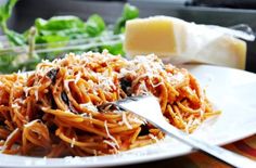 a white plate topped with pasta covered in parmesan cheese