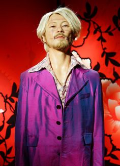 a man with white hair wearing a purple jacket