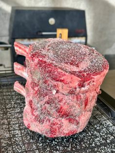 a large piece of meat sitting on top of a grill covered in powdered sugar