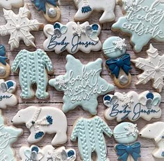 baby shower cookies decorated with blue and white icing on a wooden surface, including snowflakes