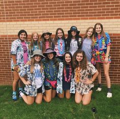 a group of young women standing next to each other in front of a brick wall