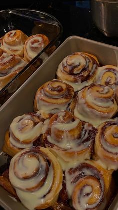 two pans filled with cinnamon rolls sitting next to each other