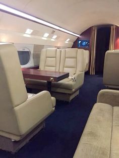 the inside of an airplane with couches and tables