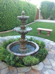 a water fountain in the middle of a garden