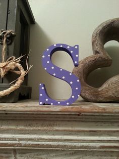 a wooden letter sitting on top of a mantle