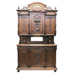 an ornate wooden cabinet with carvings on the front and sides, against a white background