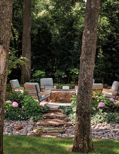 an outdoor seating area surrounded by trees and flowers