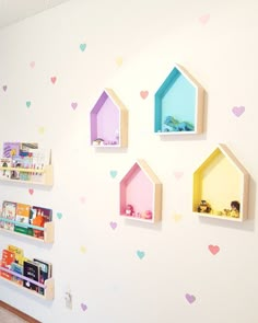 the wall is decorated with little houses and bookshelves for children's playrooms