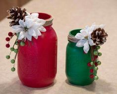 two mason jars decorated with flowers and pine cones