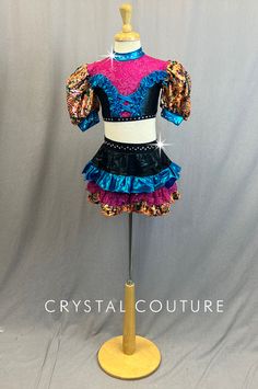 Multi colored patterned lycra includes Orange, Turquoise Blue and Fuchsia. Multi colored fabric creates puffy sleeves and bottom ruffle of skirt with Blue shiny lycra ruffle accents on top as well as ruffle on the skirt. Pink glitter lace ruffle on the skirt as well as neckline and chest of crop top. Black shiny lycra pulls it all together with crystal 20ss rhinestones to trim top and belt of skirt. *Accessories include Black sheer fingerless gloves with Blue bows at wrists, and 2 Multi colored Fitted Ruffled Skirt For Costume Party, Fitted Purple Skirt With Ruffles, Blue Fitted Skirt With Ruffles, Fitted Blue Skirt With Ruffles, Fitted Multicolor Skirt With Attached Cancan, Fitted Blue Skirt With Attached Cancan, Sheer Fingerless Gloves, Skirt Accessories, Orange Turquoise