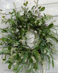 a wreath with white flowers and green leaves