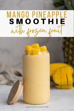 mango pineapple smoothie with frozen fruit in a mason jar on a white table