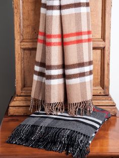 a brown and black checkered blanket sitting on top of a wooden table next to a door