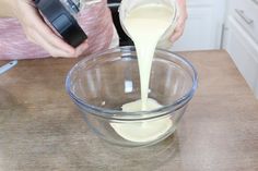 a person pouring milk into a bowl on top of a counter