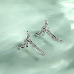 These sterling silver dragonfly earrings are symbolic of a lighter and brighter outlook on life - reminding us to live life to the fullest. This piece is undeniably shimmering and powerfully eye-catching - a dragonfly weaving through an earlobe is rarely seen! They make a delicate and meaningful gift for a loved one. Love life with our cute dragonfly climber earrings!Carat Weight: 0.748 ctStone Size: 1,1.2,1.3 mmStone Type: Jeulia® StoneNumber of Stones: 64 Stone Shape: RoundStone Color: Diamond Elegant Sterling Silver Dragonfly Earrings, Elegant Dragonfly Jewelry With Ear Wire, Elegant Dragonfly Earrings With Ear Wire, Elegant Silver Ear Climbers As Gift, Elegant Silver Ear Climbers For Gifts, Silver Fine Jewelry Ear Climbers As Gift, Silver Ear Climbers Fine Jewelry Gift, Cute Dragonfly, Live Life To The Fullest