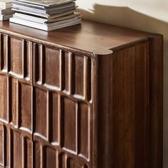 a wooden cabinet with books on top of it