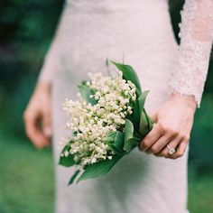 a bride holding a bouquet of flowers in her hand