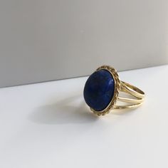 Lapis lazuli - richly blue and in excellent shape. This massive lapis is held in a beautiful vintage ring crafted in 18K yellow gold with beautiful braided bezel detail. The shank splits in three different bands tapering down to a single band at the bottom of 4.30mm This ring is currently a size 8.5 but can be sized down upon request. With any pre-owned/Vintage/Antique items, it is common to have some wear, As we inspect each piece of our jewelry, we make sure the wear and tear is acceptable wit Elegant Blue Oval Cabochon Signet Ring, Blue Cabochon Sapphire Ring In 14k Gold, Formal Lapis Lazuli Gemstone Ring, Elegant Blue Gemstone Dome Ring, Timeless Blue Oval Cabochon Jewelry, Blue 14k Gold Oval Cabochon Rings, 14k Gold Blue Oval Cabochon Rings, Elegant Blue Cabochon Dome Ring, Classic Blue Lapis Lazuli Rings