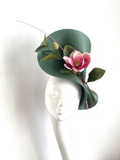 Bottle green magnolia fascinator Bottle green magnolia fascinator hat will be an amazing accessory to compliment your outfit. The fascinator will fit the average head size. Its made from silk covered headband attached to the green polybraid saucer base on which sits a pink magnolia flower and a pink feather. To secure your fascinator there is a comb inside the hat attached to the headband, so the fascinator sits very securely on your head. Enjoy your special day with this beautiful headpiece! ht Floral Fascinators Hair Pieces, Luxury Green Hat For Royal Ascot, Fresh Flower Fascinator, Green Summer Fascinator With Handmade Flowers, Kentucky Derby Green Fascinator With Handmade Flowers, Green Fascinator With Handmade Flowers For Spring, Green Spring Fascinator With Handmade Flowers, Green Handmade Flowers Fascinator For Spring, Whimsical Green Hat With Curved Brim