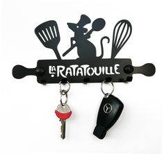 a key holder with two keys hanging from it's hooks and the word ratatoulie