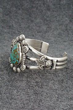 This stunning Kingman turquoise and sterling silver bracelet was made by Navajo silversmith Rosita Calladitto. The back is signed R Calladitto and stamped Sterling.Size: 5 5/8" (will fit up to a 6 3/4" wrist)Gap: 1 1/8"Width: 1 5/8"Cuff Width: 1/2"Free shipping on all orders! We ship with USPS and always include tracking. All orders ship within a day of payment.Returns are accepted up to 30 days after you receive your order. Just send us a message. Our shop offers cash back or store credit. The Elegant Sterling Silver Bracelet With Turquoise, Artisan Turquoise Cuff Bracelet In Sterling Silver, Artisan Turquoise Sterling Silver Bracelet, Unique Turquoise Sterling Silver Bracelets, Engraved Turquoise Sterling Silver Bracelet Gift, Elegant Engraved Turquoise Sterling Silver Bracelet, Elegant Turquoise Engraved Sterling Silver Bracelet, Turquoise Sterling Silver Cuff Bracelet With Inlay, Sterling Silver Turquoise Cuff Bracelet With Inlay