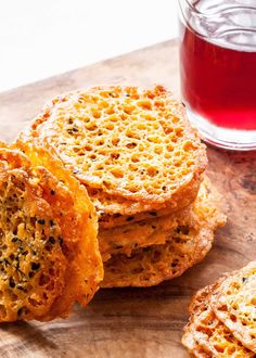 several pieces of bread sitting on top of a wooden cutting board next to a cup of tea