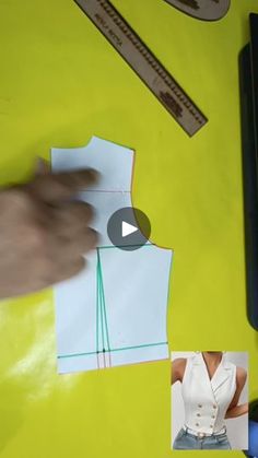 a person cutting paper with scissors and sewing supplies on a yellow table top next to a pair of scissors