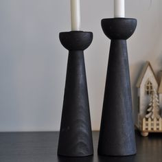 two black candlesticks sitting next to each other on a table