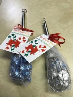 two candy canes wrapped in clear cellophane and tied with red ribbon are sitting next to each other