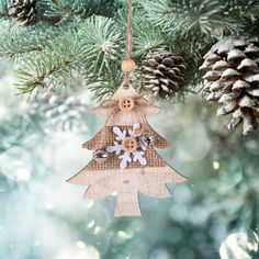 a christmas tree ornament hanging from a pine tree with buttons and snowflakes