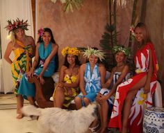 a group of women in bathing suits posing for a photo with a dog on the floor