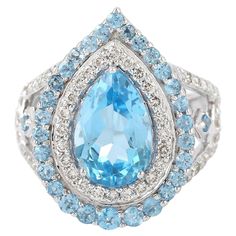 This stunning ring has been meticulously crafted from 18-karat gold. It is hand set in 5.43 carats blue topaz and illuminated with .91 carats of glittering diamonds. The ring is a size 7 and may be resized to larger or smaller upon request. FOLLOW MEGHNA JEWELS storefront to view the latest collection & exclusive pieces. Meghna Jewels is proudly rated as a Top Seller on 1stDibs with 5 star customer reviews. All items manufactured by us are handmade and can be customized or redesigned. Compositio Luxury Hallmarked Collectible Topaz Ring, Luxury Blue Topaz Halo Ring, Fine Blue Topaz Ring Pear-shaped, Fine Jewelry Blue Pear-shaped Topaz Ring, Dazzling Blue Topaz Ring, Blue Pear-shaped Topaz Ring With Center Stone, Dazzling Blue Topaz Ring With Center Stone, Blue Topaz Pear-shaped Ring With Center Stone, Dazzling Blue Topaz Ring With Accent Stones